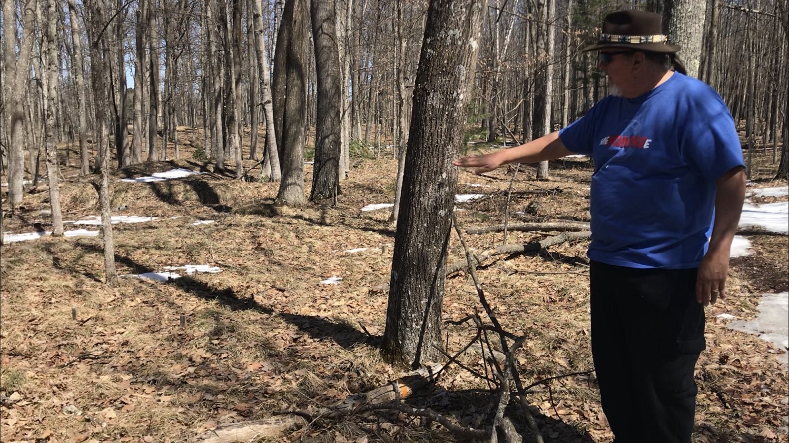 man points to mounds on the ground