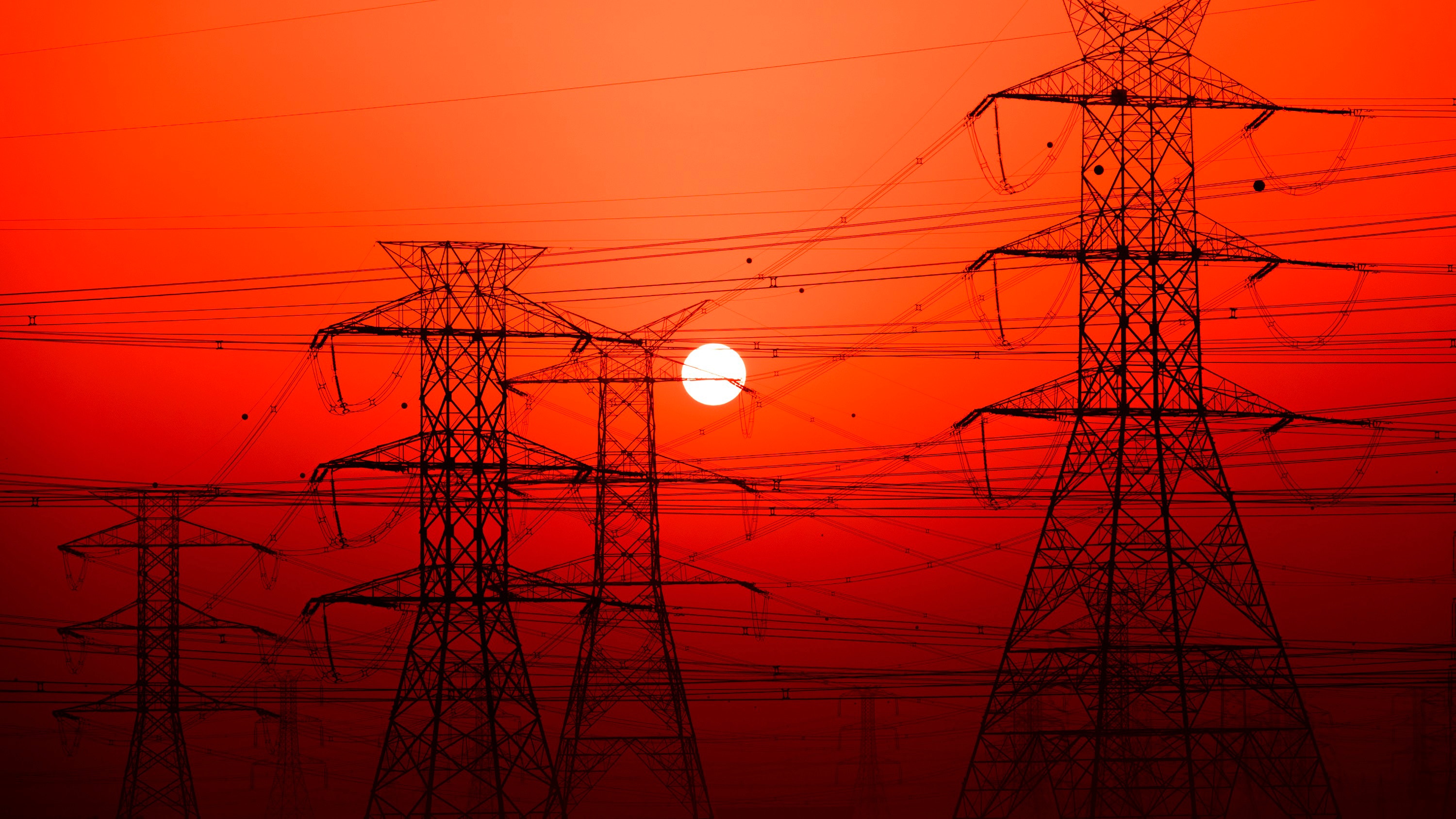 Powerlines set against a red sky