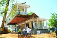 Image: home being lowered onto foundation. Topic: High Impact Community Investing