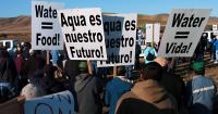 Image: marchers carrying signs, "Agua es nuestro futuro." Title: The Power of Latino Voices in Environmental Justice