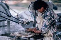 Image: laborer working with machinery. Topic: Fair labor.