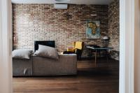 living room with brick walls, a grey couch and a cartographer's map of Africa on the wall