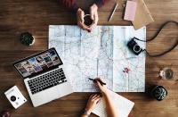 Image: map, laptop, camera, and notepad on table. Title: Eco-Travel Checklist