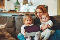 mother and children playing on ipad