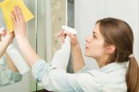 Image: woman spraying cleaning product on glass. Title: Green Cleaning Products Our Staff Love