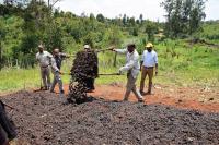 Ethiopian farmers dumping compost on field.