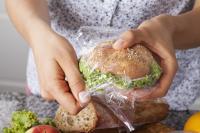 woman wraps sandwich in plastic