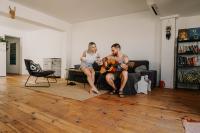 Image: man and woman in living room with wood flooring. Topic: Eco-friendly flooring