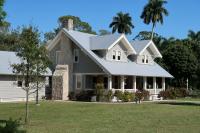 a gray suburban style house with a green yard.