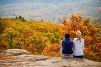 Two people look over a scenic fall landscape