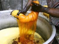 Image: person wringing out dyed fabric. Topic: Toxic Textiles Report