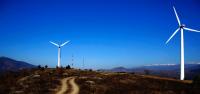 Image: wind turbines against a clear blue sky. Title: The Power of Divestment