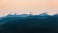 Image: wind turbines on a ridgeline. Topic: socially responsible investing can include energy from wind