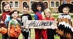 Image: children in Halloween costumes holding sign, "Halloween." Title: Is There Child Labor in Your Halloween Candy? Chocolate Scorecard Identified Good, Ghoulish Companies