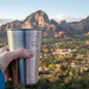 SoulCup by Soulbottles in hand with town and mountains in background.