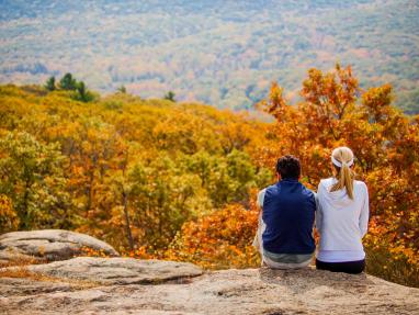 Two people look over a scenic fall landscape