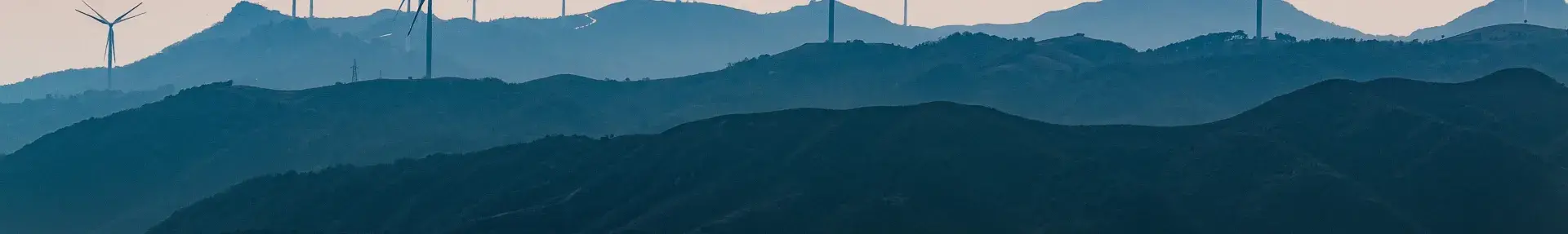 Image: wind turbines on a ridgeline. Topic: socially responsible investing can include energy from wind