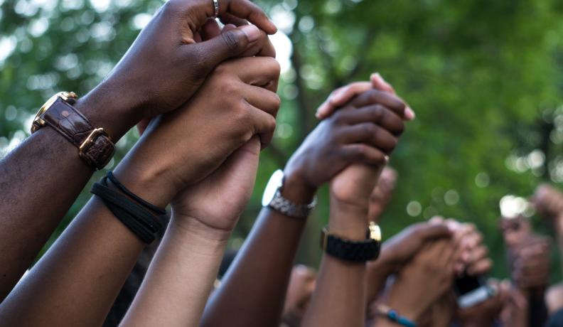 Image: holding hands. Topic: People of Color Are on the Front Lines of the Climate Crisis