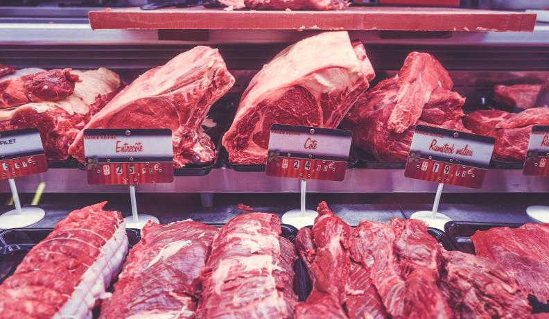 Image: rows of red meat in grocery case. Topic: Go Vegetarian: Eat Less Meat to Cool the Planet