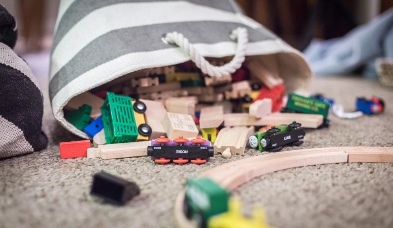 a bag of wooden toys by a train set