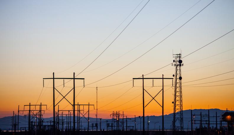 Image: telephone wires stretching across the horizon. Title: Energy Efficiency: The Magic Bullet