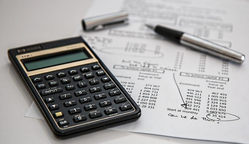 Image: calculator with financial ledger. Topic: The 5 Coolest Financial Calculators