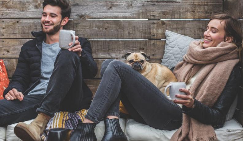 couple laughing with dog. 