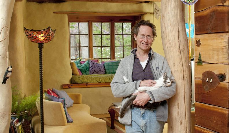 Bill Hutchins with his cat in his sunroom