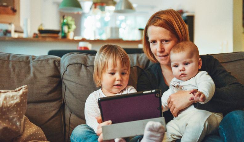 mother and children playing on ipad