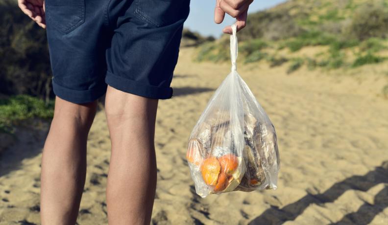 holding a plastic bag of compost