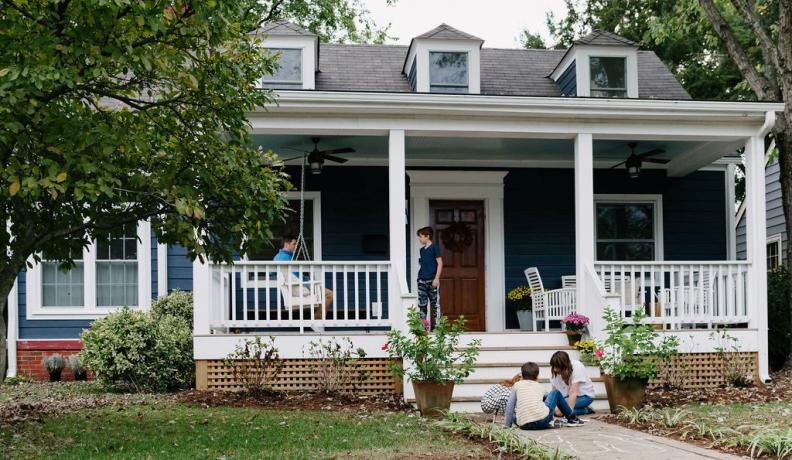 family in front of a blue house