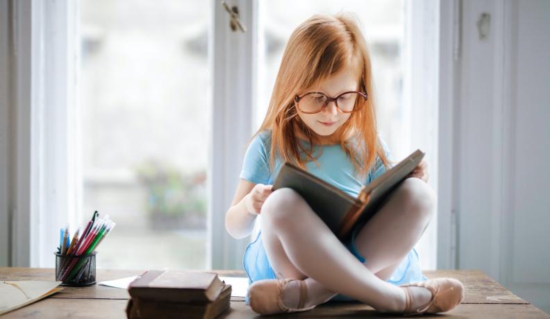 Little girl reading a book.