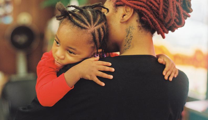 A Black mother and daughter embrace. Photo via Stocksy.