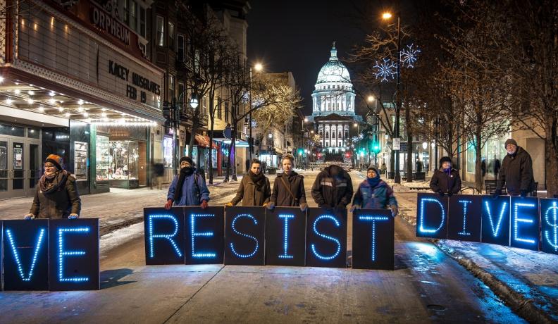 Activist group The Overpass Light Brigade poses at a Global Divestment Day event to promote divestment from fossil fuels on University of Wisconsin’s campus in February 2014. Photo by depthandtime on Flickr. 