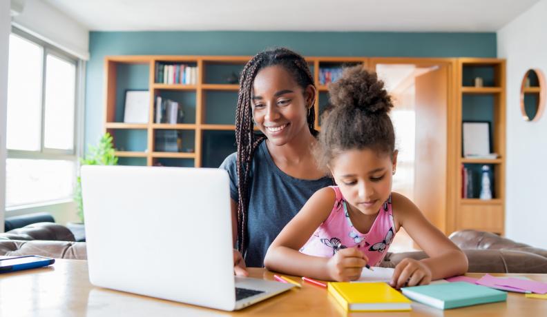 woman and daughter sitting at the computer