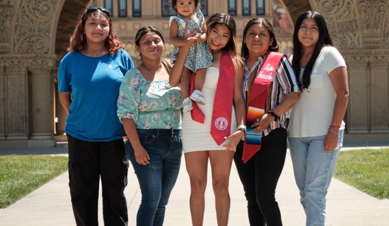 Brenda lvarez-Lagunas standing with her family members celebrating her graduation. Everyone is smiling at the camera.