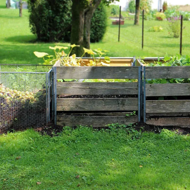 Image: three compost bins in a yard. Topic: 6 Popular Composting Options