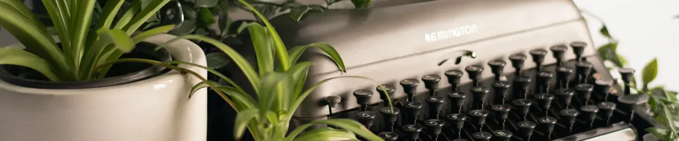 A typewriter surrounded by plants; words are often a key element of greenwashing.