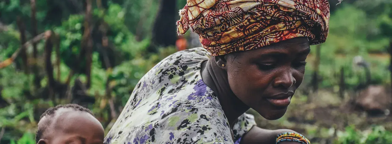 Image: baby on mother's back. Topic: What Is Fair Trade and Fair Labor?