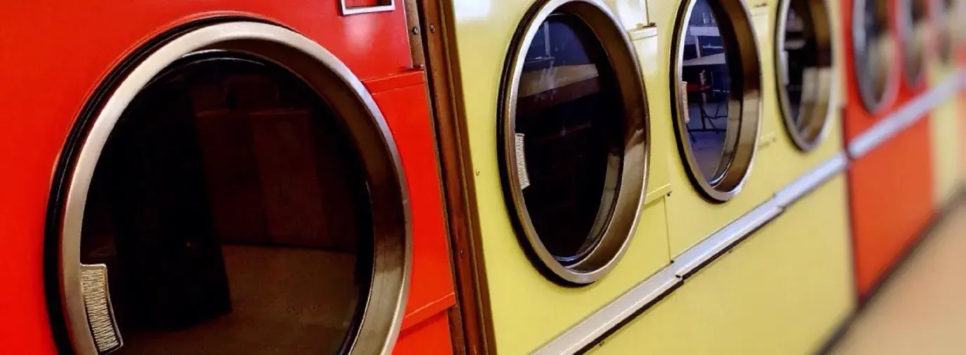 Image: colorful dryers in a laundramat. Topic:5 Reasons to Ditch your Clothes Dryer