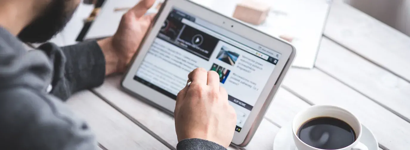 Image: man on tablet with a cup of coffee. Title: FAQs about Shareholder Activism