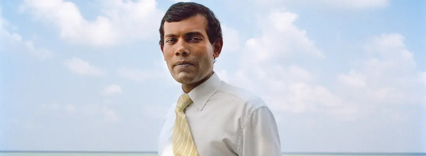 Image: Mohamed Nasheed standing on beach. Title: Mohamed Nasheed: Climate Champion for the World’s Most Vulnerable