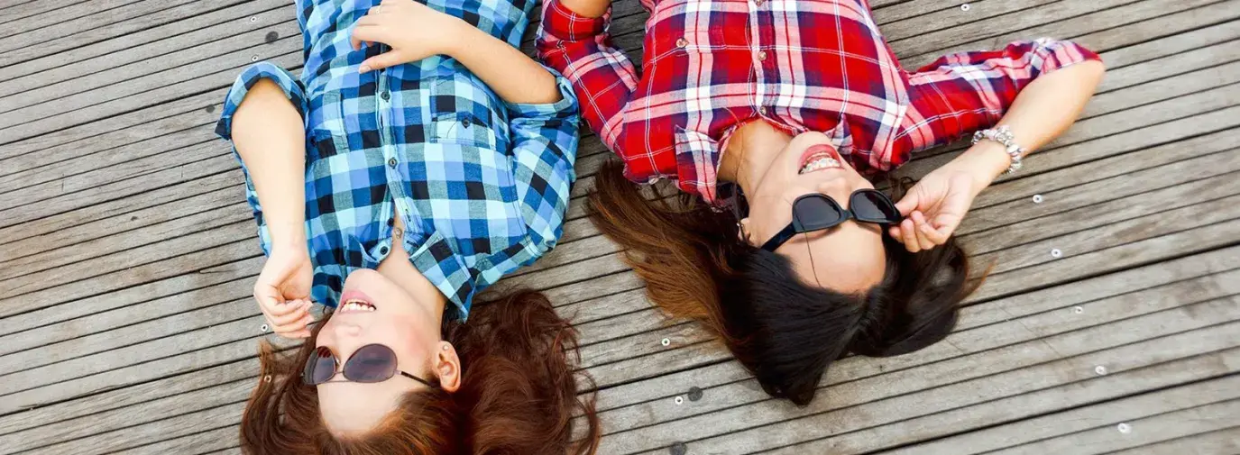 Two women with plaid shirts via Pexel