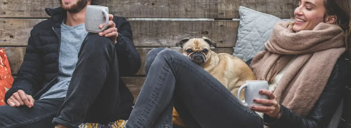 couple laughing with dog. 