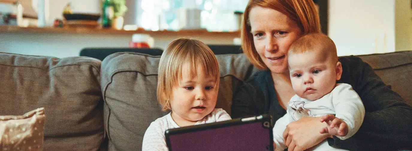 mother and children playing on ipad