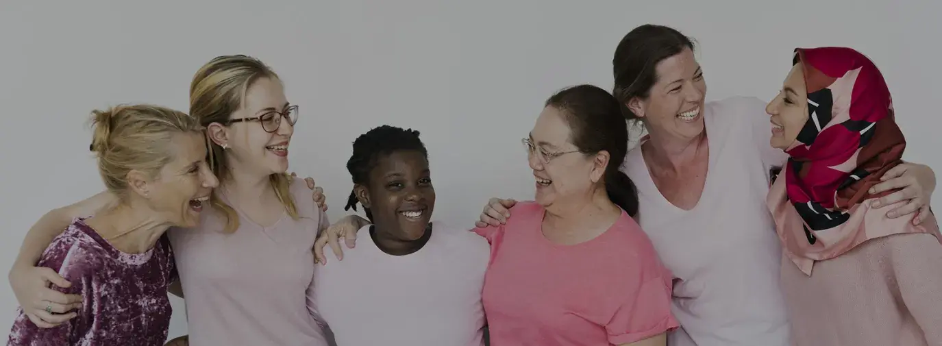 Image: diverse group of women embracing and smiling. Title: Why Investing in  Women Pays Off