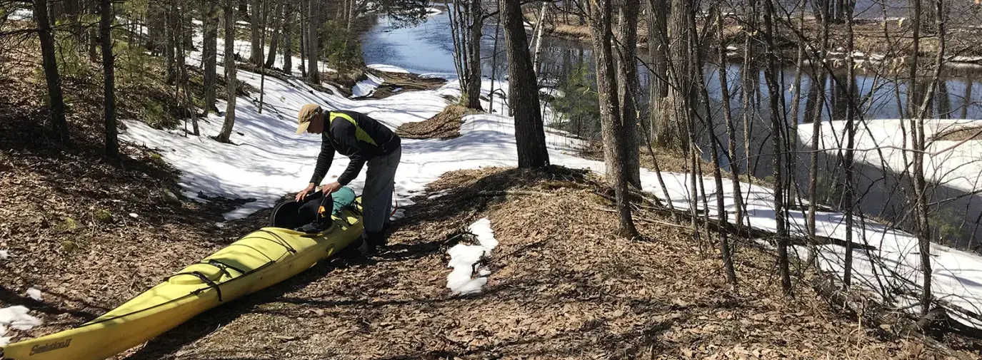 man pulls kayak out of Menominee offshoot