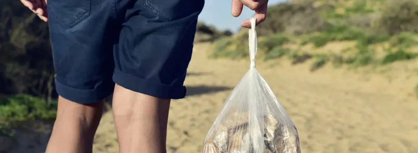 holding a plastic bag of compost