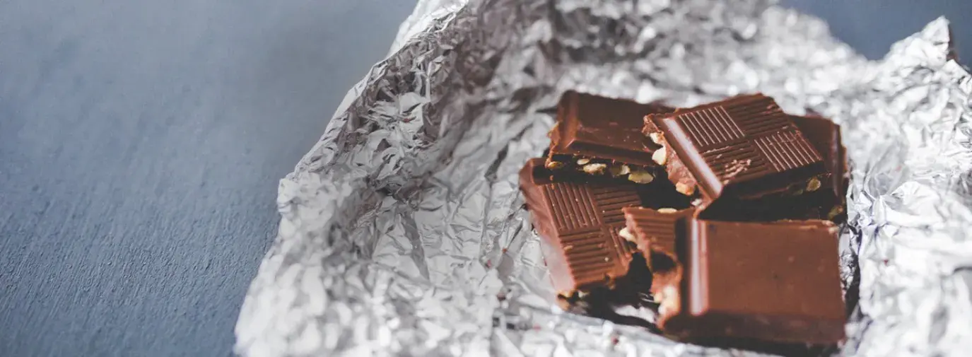 Image: chocolate bar. Title: As Valentine's Approaches, Major Retailers Rated on Whether Chocolate Products Address Child Labor, Deforestation and Fair Trade