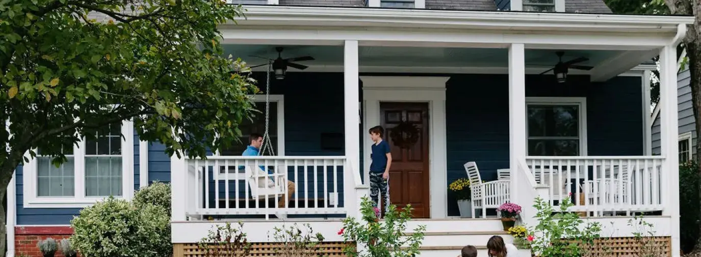 family in front of a blue house